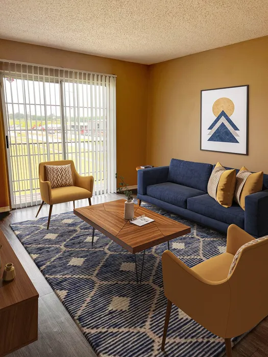Chic living room with plush navy sofa, modern armchairs, and elegant wooden coffee table, complemented by natural light from large sliding doors.