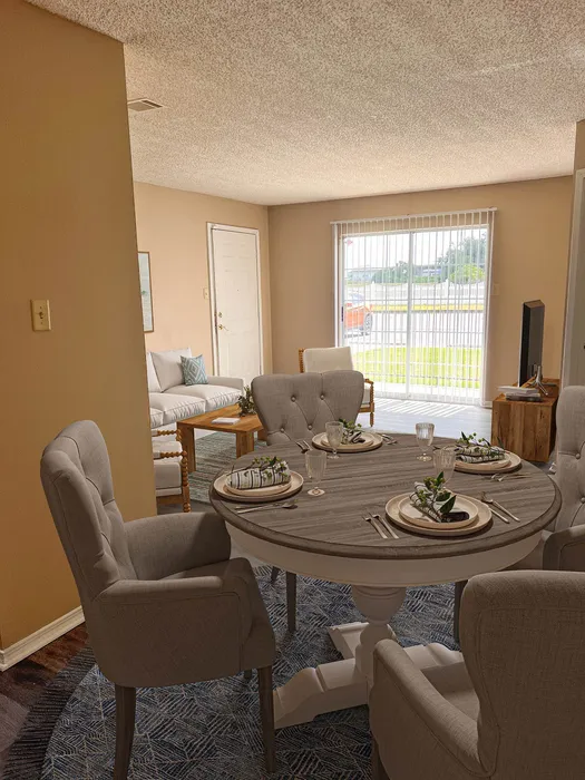 Charming dining area in open-concept living space, featuring elegant chairs and a stylish round table set for four, with views of a bright and inviting living room.