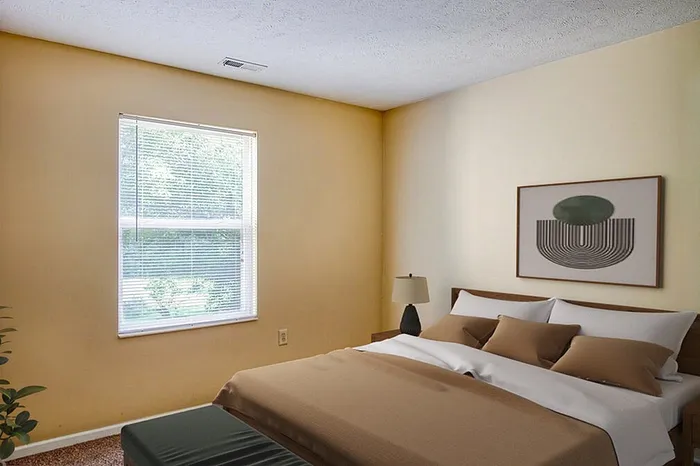 Bright and cozy bedroom with a large window, modern decor, and neutral tones, offering a serene and welcoming atmosphere.