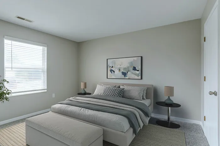 Serene bedroom oasis with stylish gray bedding, modern artwork, and natural light streaming through a large window.