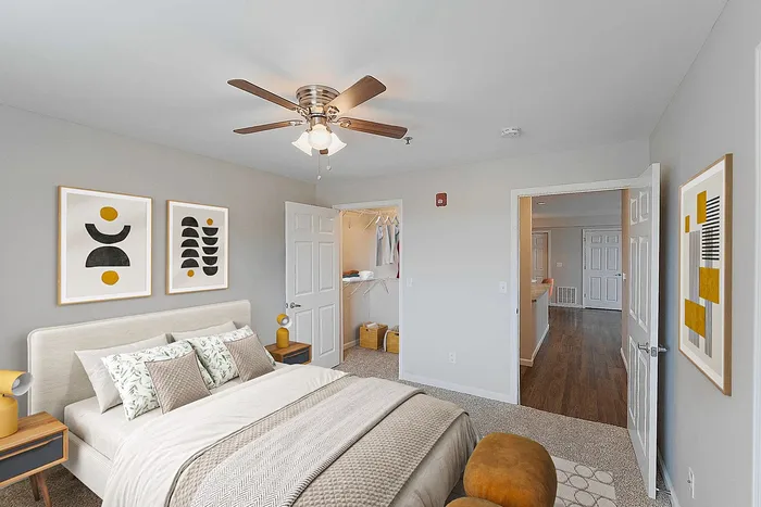 Elegant bedroom with modern decor, featuring a cozy bed, stylish artwork, and a spacious walk-in closet. Perfect blend of comfort and sophistication.