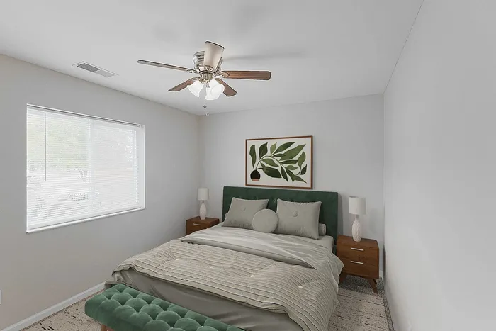 Welcoming bedroom featuring a plush bed with green accents, elegant side lamps, modern ceiling fan, and a large window enhancing natural light.