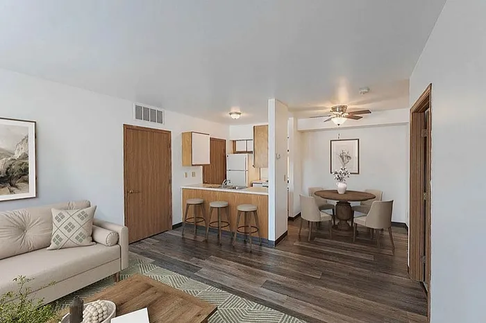 Bright and inviting open-plan living area featuring modern kitchen with breakfast bar, cozy dining nook, and elegant hardwood floors.