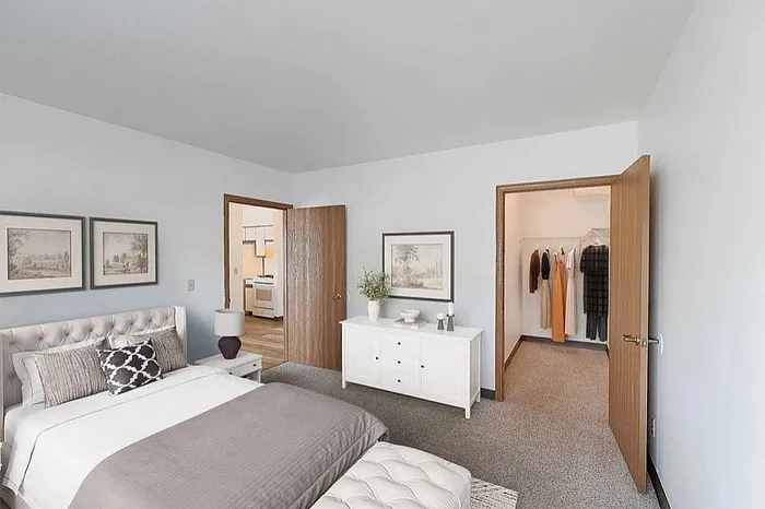 Elegant bedroom with plush bed, stylish decor, and spacious walk-in closet, offering comfort and luxury.