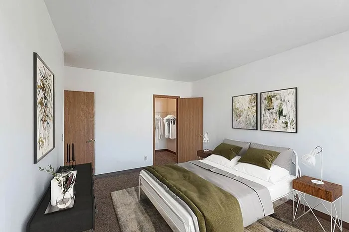 Inviting modern bedroom with elegant decor, featuring a spacious walk-in closet, stylish artwork, and cozy bedding.