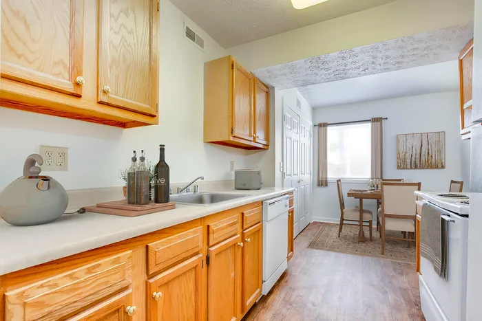 Bright and welcoming kitchen with natural wood cabinets and cozy dining area, perfect for intimate gatherings.