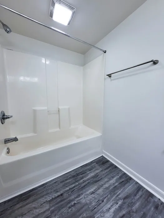Modern bathroom featuring a sleek white bathtub and elegant gray flooring, perfect for relaxation.