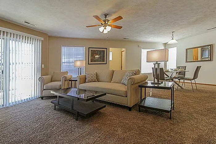 Inviting open-concept living room with plush seating, stylish lighting, and adjacent dining area, perfect for entertaining.