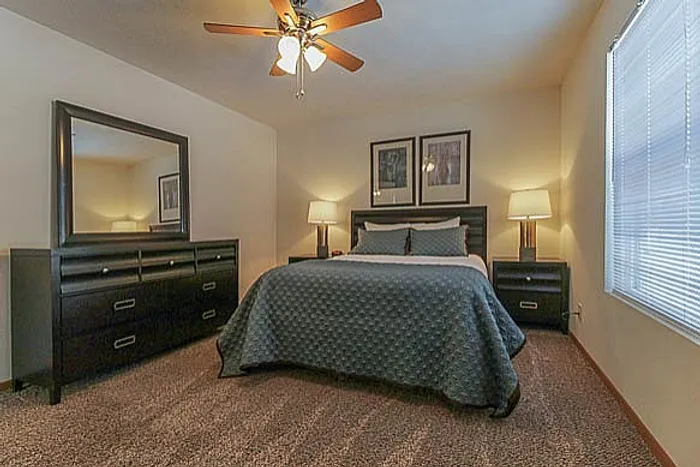 Elegant bedroom with a cozy double bed, stylish dark wood furniture, and ambient lighting from bedside lamps.