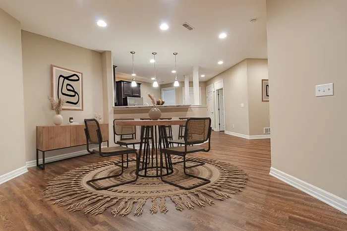 Elegant dining area with modern lighting and stylish decor, featuring natural wood tones and designer artwork.