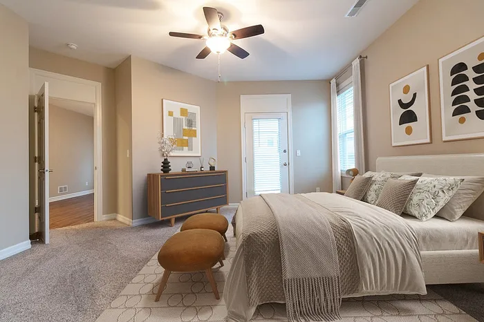 Inviting bedroom featuring elegant decor, neutral tones, and ample natural light, perfect for relaxation and comfort.