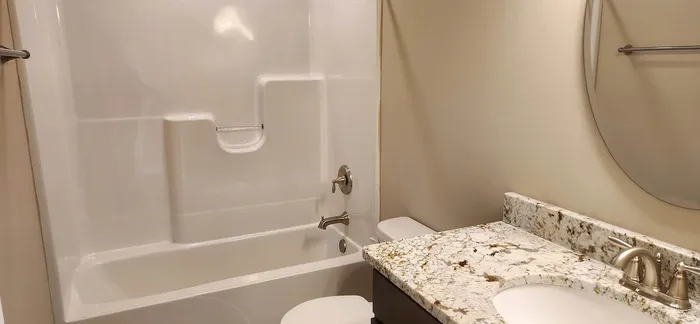 Elegant bathroom showcasing a sleek bathtub and luxurious granite countertop.