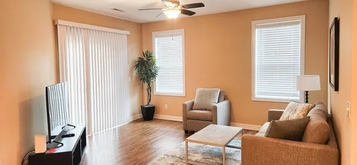 Inviting living room with warm tones, modern furniture, and abundant natural light through large windows.
