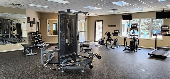 Modern fitness center with state-of-the-art gym equipment, large windows for natural light, and an inviting atmosphere for an energizing workout.