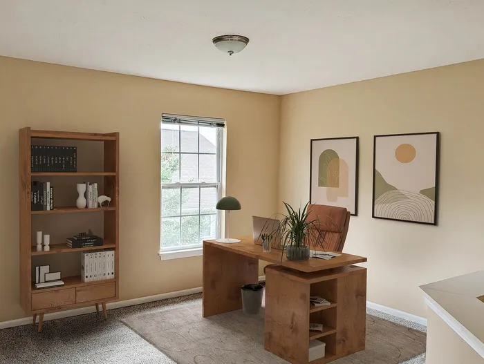 Inviting home office with elegant wooden desk, chic decor, and natural light from a large window.