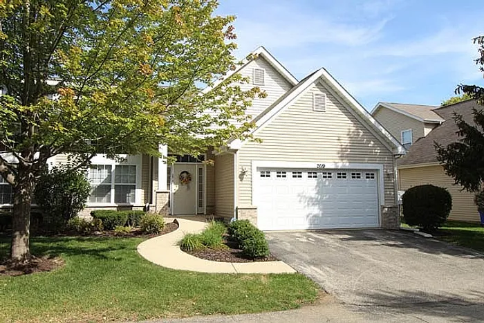 Charming suburban home with a welcoming front entrance, two-car garage, and manicured landscaping in a peaceful neighborhood setting.