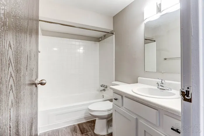 Modern bathroom with elegant white tiles, sleek fixtures, and stylish vanity, offering a clean and refreshing ambiance.