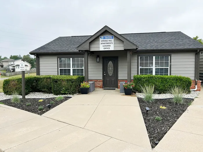 Charming leasing office of Spring Hill Apartments with welcoming greenery and modern exterior design.