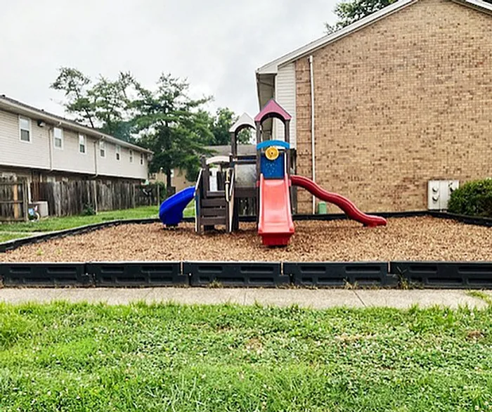 Charming community playground with colorful slides and climbing structures, ideal for family living.