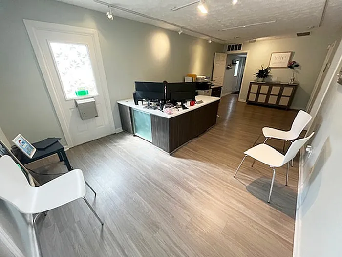 Inviting office space with sleek wooden floors, modern furniture, and ample natural light, perfect for a productive work environment.