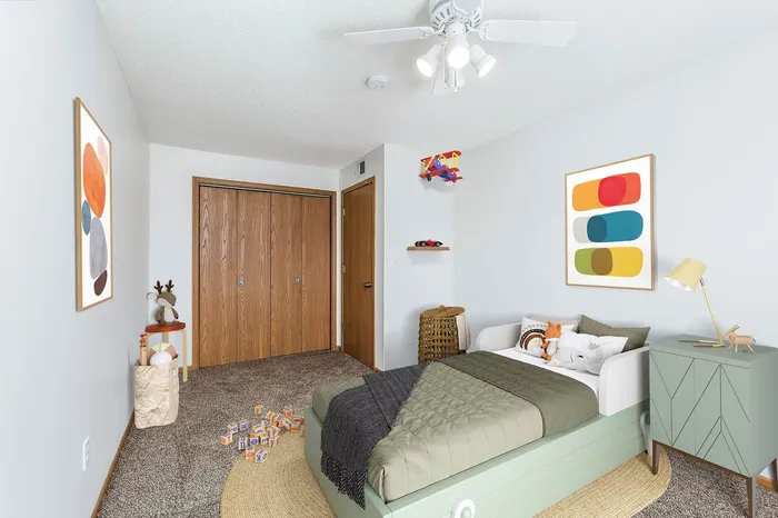 Charming children's bedroom featuring a cozy bed with decorative pillows, creative wall art, and a set of playful alphabet blocks on soft carpet.