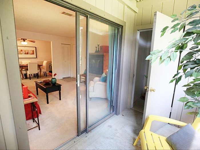 Inviting apartment interior with glass doors opening to cozy living room, stylish decor, and a glimpse of the chic dining area.