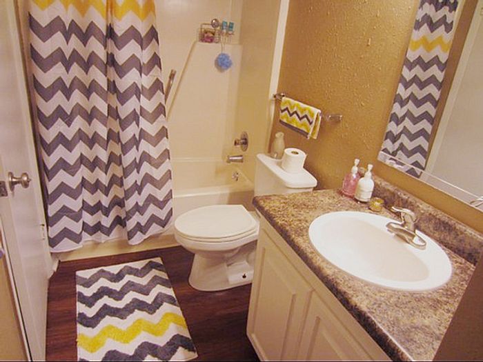 Charming bathroom with modern chevron accents, elegant countertop, and pristine fixtures.