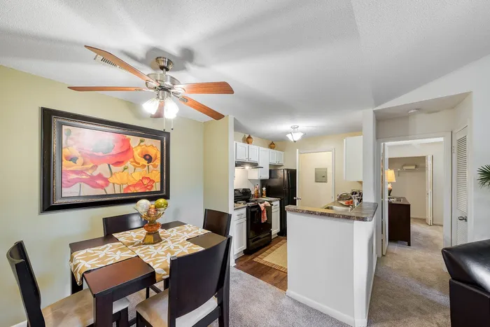 Inviting open-concept apartment kitchen and dining area with modern furnishings, elegant lighting, and vibrant art.