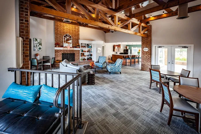 Charming communal space with exposed wooden beams, cozy seating areas, and a welcoming fireplace, perfect for relaxation and gatherings.