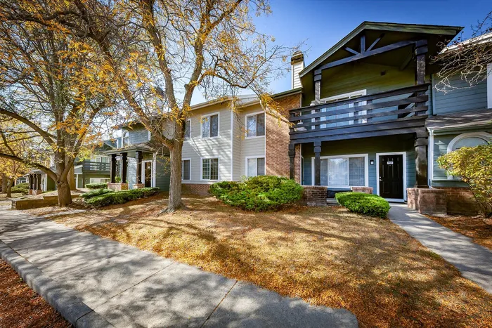 Charming suburban apartment complex with autumn foliage, showcasing inviting architecture and black accents.