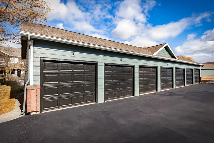 Captivating row of modern garages with sleek black doors, set against a beautiful blue sky, perfect for convenient and secure parking.