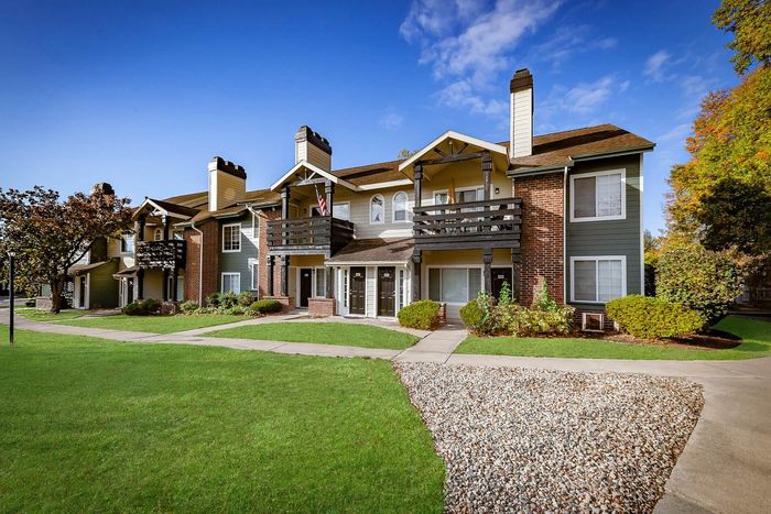 Charming apartment complex with classic architecture, lush green lawns, and a serene neighborhood setting.