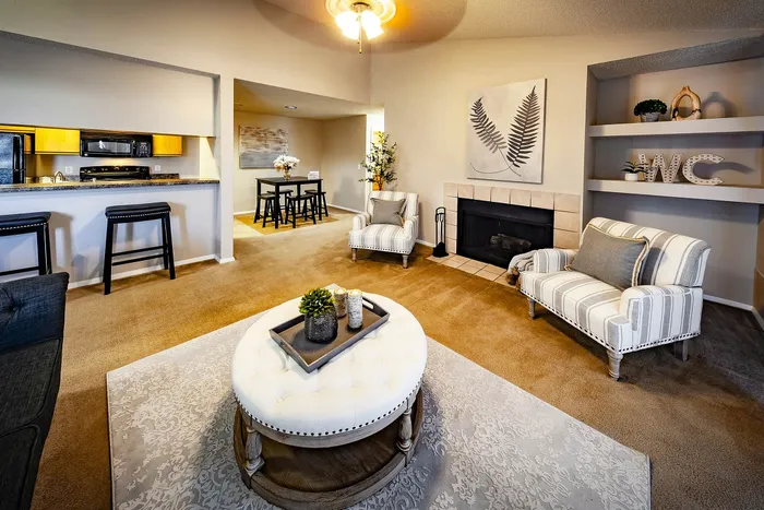 Inviting living space with plush seating, modern fireplace, and elegant dining area adjacent to a sleek open kitchen.