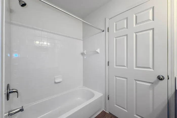 Pristine bathroom featuring a classic white bathtub, modern fixtures, and elegant tilework, perfect for tranquil relaxation.