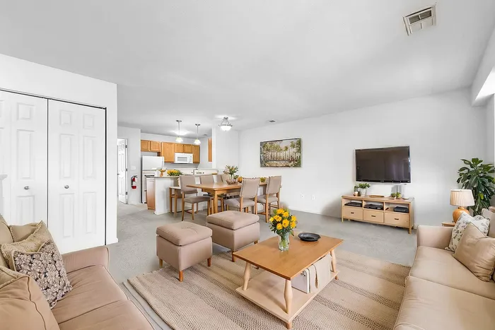 Inviting open-concept living and dining area featuring modern furnishings, abundant natural light, and a well-equipped kitchen.