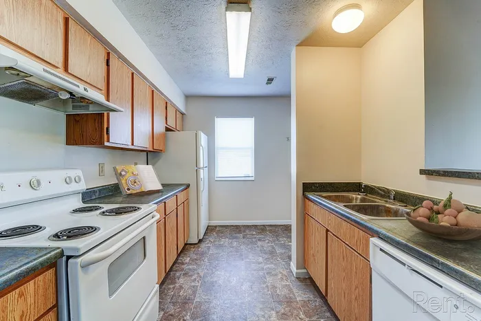 Inviting kitchen with modern appliances, ample wooden cabinetry, and sleek countertops, perfect for culinary creativity.
