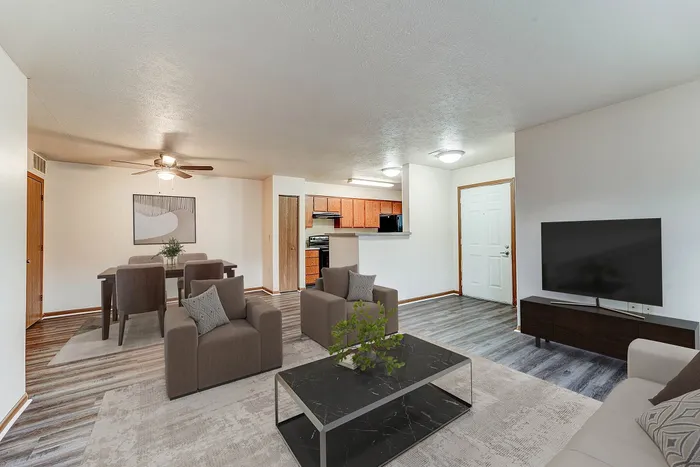Inviting open-concept living and dining area with modern furnishings, stylish lighting, and a functional kitchen with wooden cabinetry.