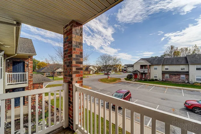 Charming balcony view overlooking a tranquil neighborhood with well-maintained lawns and vibrant autumn foliage.