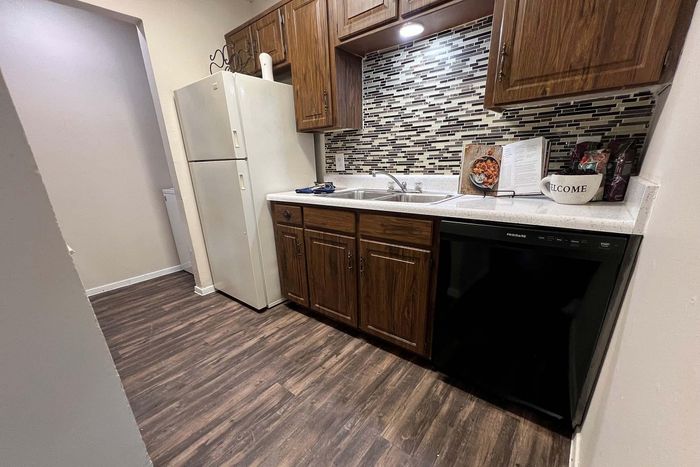 Cozy kitchen with elegant wooden cabinets, modern backsplash, and sleek appliances, perfect for culinary creations.