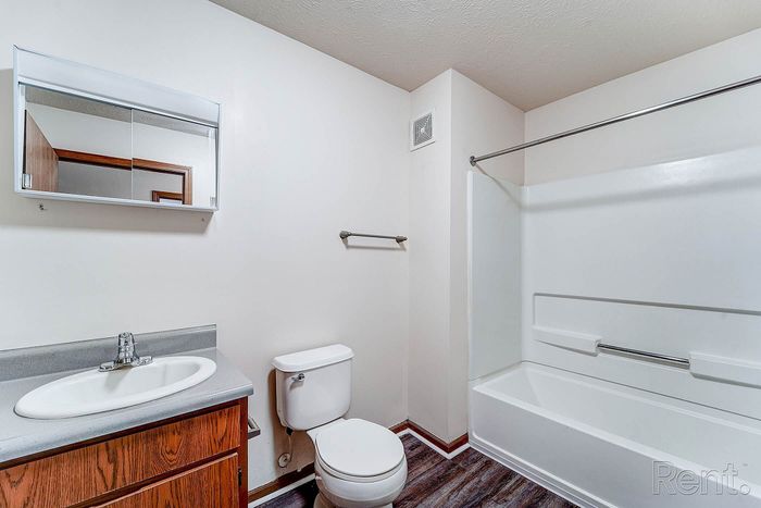 Modern bathroom with sleek fixtures, large mirror cabinet, and elegant wood vanity offering ample storage.
