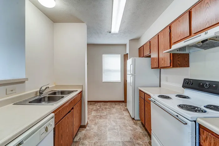 Bright and modern kitchen featuring sleek countertops, ample cabinetry, and top appliances in a stylish apartment.
