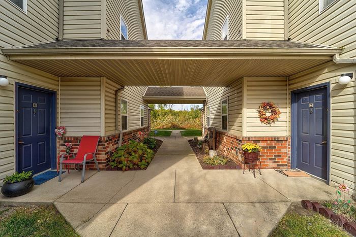 Charming apartment entrance with inviting seating area and vibrant decorative plants, offering a warm welcome.