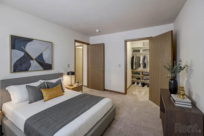 Elegant bedroom with a plush bed, stylish decor, and an organized walk-in closet for a luxurious living experience.