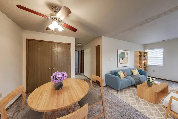 Inviting living space with a cozy sofa, chic dining area, and modern decor, illuminated by natural light from the window.