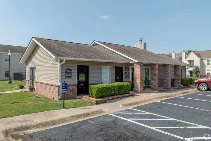 Charming apartment complex exterior with stylish brick and siding design, featuring a welcoming laundry center and convenient accessible parking.