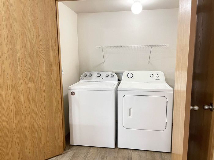 Modern laundry area featuring sleek washer and dryer set within a cozy closet space.