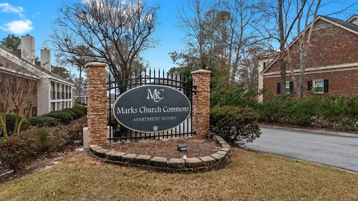 Welcoming entrance to Marks Church Commons, showcasing elegant brick architecture and lush surroundings.
