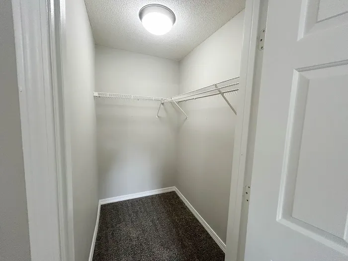 Spacious walk-in closet with built-in shelving, perfect for ample storage in a modern apartment.