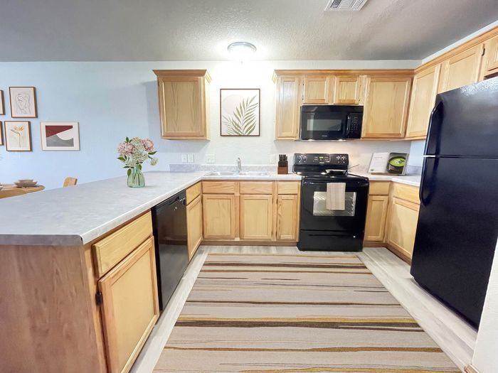 Bright and airy kitchen featuring modern appliances, elegant wooden cabinetry, and a stylish dining area adorned with contemporary artwork.