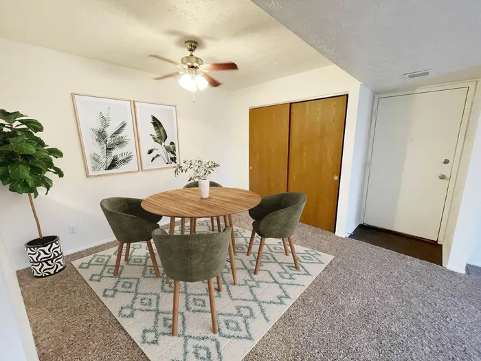 Charming dining area with a cozy round table, stylish green chairs, and elegant botanical artwork, creating a welcoming atmosphere.